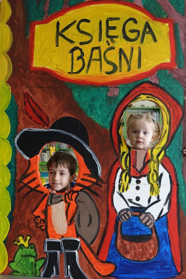 dziewczynka i chłopiec pozują do zdjęcia w fotobudce