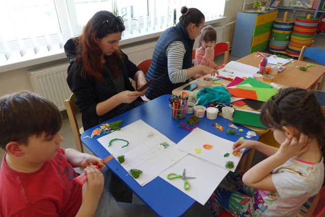 uczestnicy warsztatów z różnych materiałów tworzą książki dotykowe