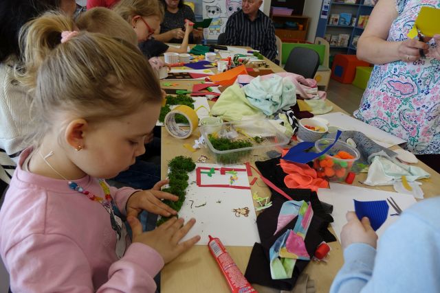 uczestnicy warsztatów z różnych materiałów tworzą książki dotykowe