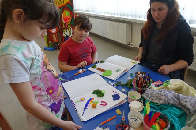 uczestnicy warsztatów z różnych materiałów tworzą książki dotykowe