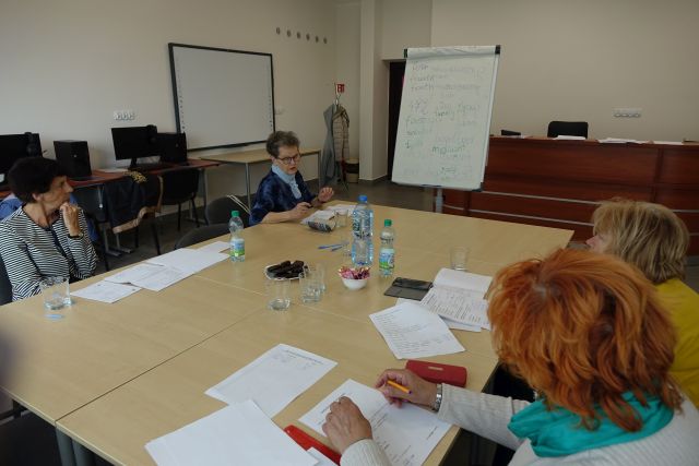 4 kobiety siedzą przy stołach i uczą się