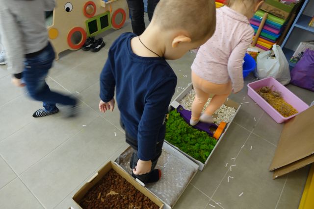 dwoje małych dzieci idzie po ścieżce sensorycznej