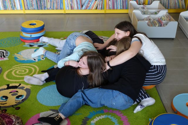 dziewczyny leżą na sobie na kolorowym dywanie