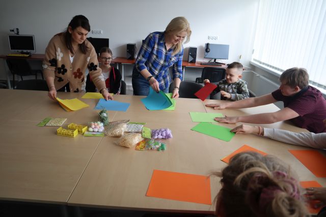 uczestnicy warsztatów wykonują koszyczki wielkanocne z papieru