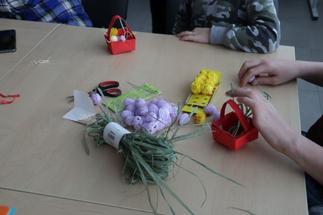 uczestnicy warsztatów wykonują koszyczki wielkanocne z papieru