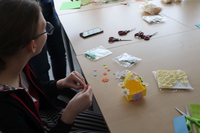 uczestnicy warsztatów wykonują koszyczki wielkanocne z papieru