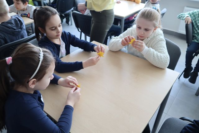 dzieci przyklejajążółte żonkile z papieru