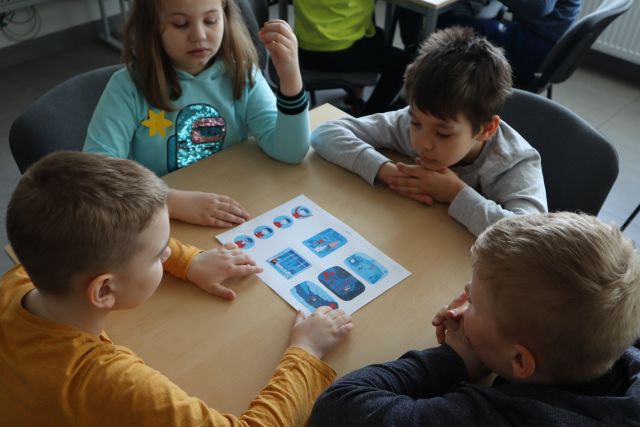 dzieci rozwiążują zadanie na kartce