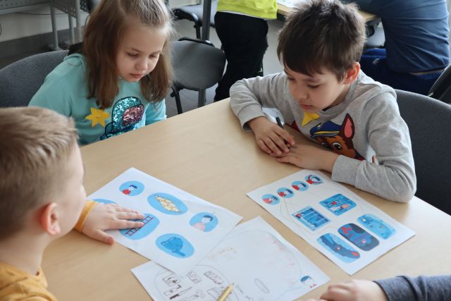 dzieci rozwiązują zadania na kartkach