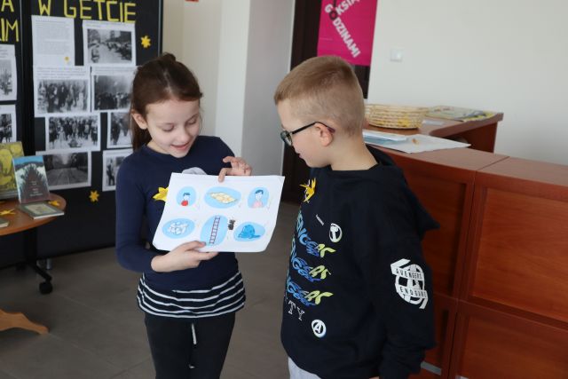 chłopiec i dziewczynka prezentują rozwiązane zadanie