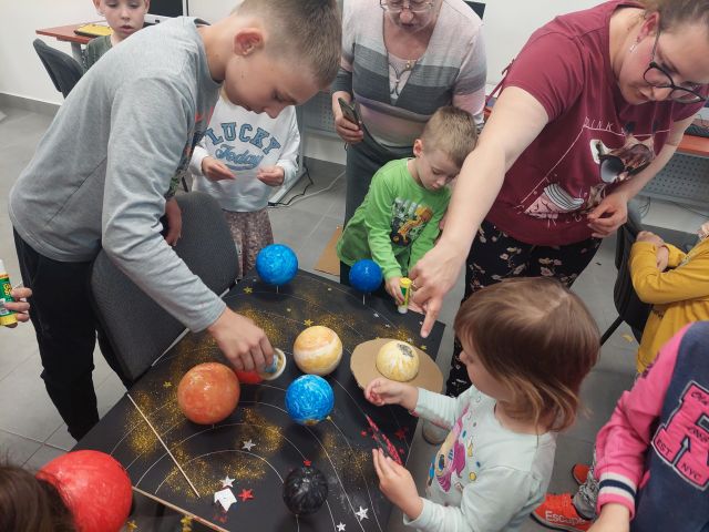 dzieci swykonują makietę z planetami ze steropianu