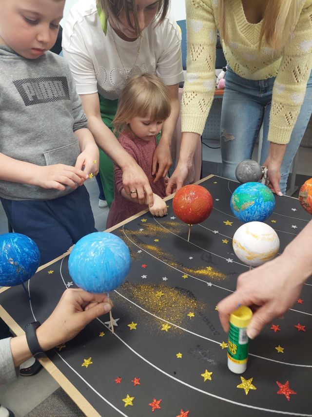 dzieci swykonują makietę z planetami ze steropianu