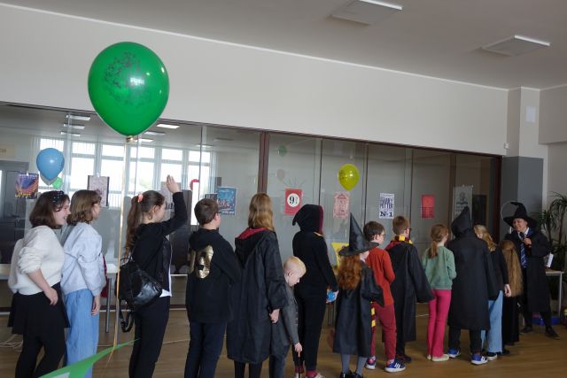 młodzież przebrana w czarne styroje stoi w kolejce