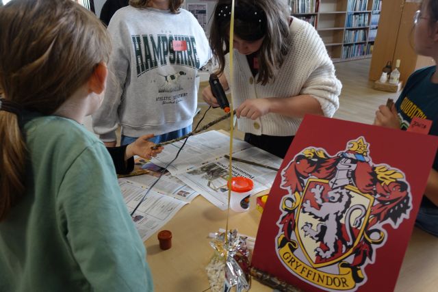 uczestnicy spotkania młodzież ozdabiają patyki i robią z nich różdżki