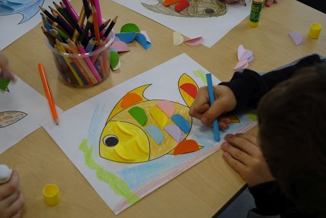 dziecko maluje kolorową rybkę