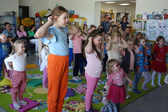 dzieci wykonują ćwiczenia z rękami podniesionymi do góry