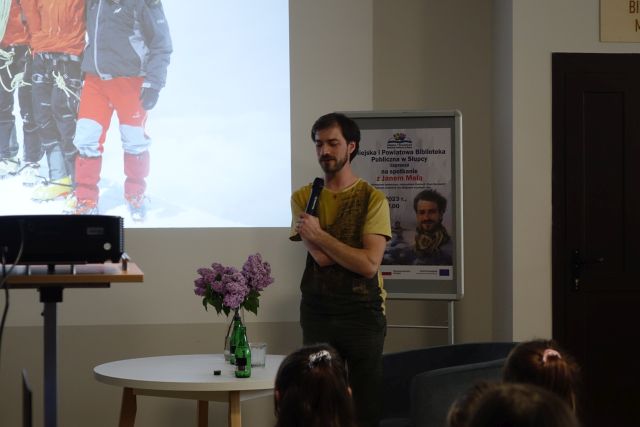 mężczyzna bez ręki trzymający mikrofon opowiada