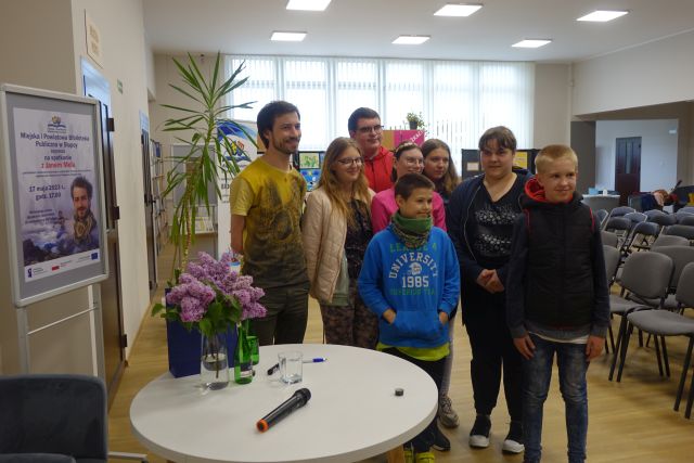 mężczyzna bez ręki pozuje do zdjęcia z młodzieżą