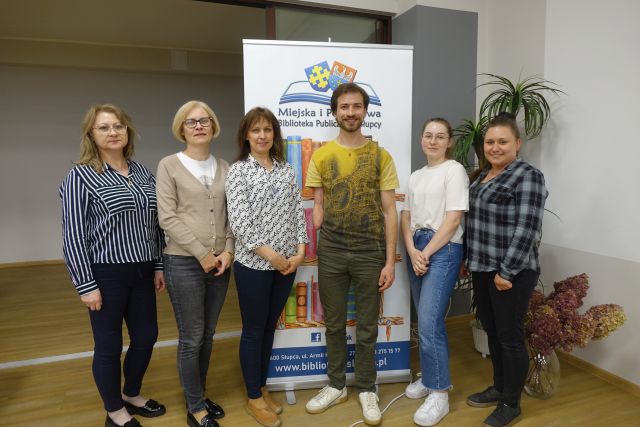 mężczyzna bez ręki pozuje do zdjęcia z 5 bibliotekarkami