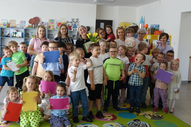 dzieci nauczycielki przedszkola bibliotekarka i pisarka pozują do zdjęcia