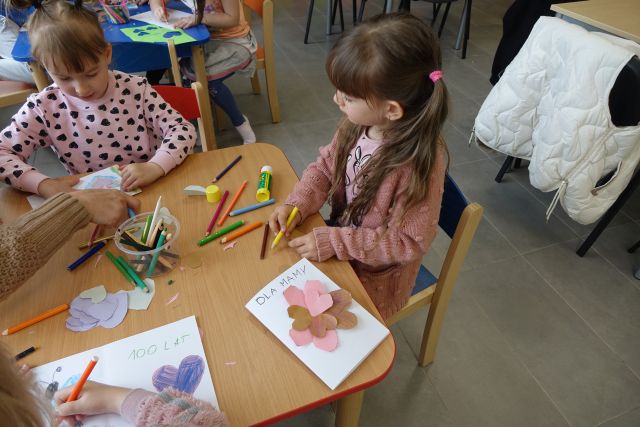 dziewczynki wykonały laurki z serduszkami wyciętymi z papieru