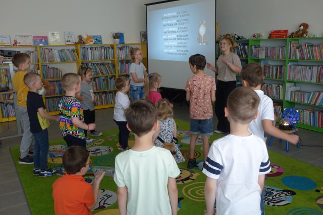 dzieci z kobietą bawią się w rytm muzyki