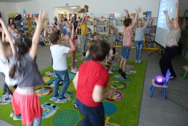 dzieci podskakują na kolorowym dywanie