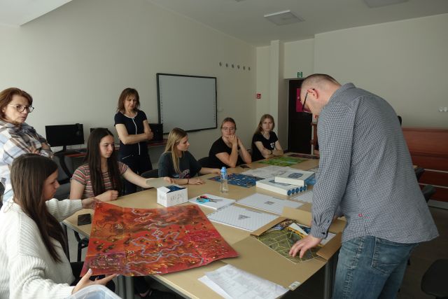 uczestnicy warsztató oglądają przykłądowe plansze gier