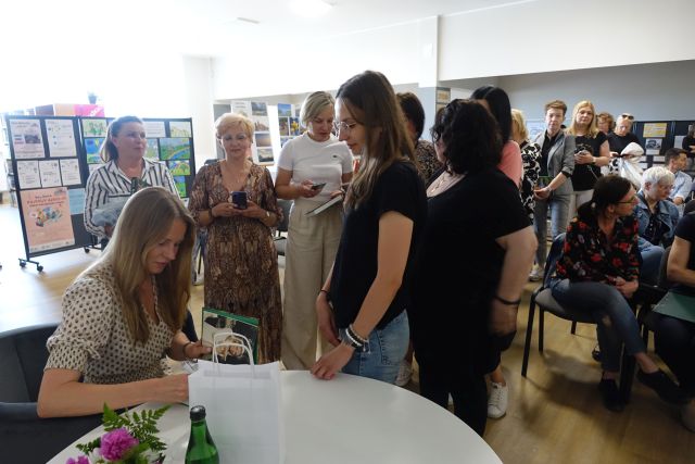 uczestnicy spotkania czekają na autograf
