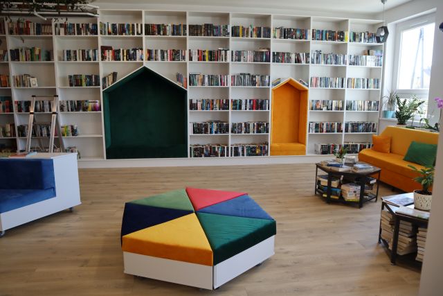 białe regały z książkami, przed nimi kolorowy box