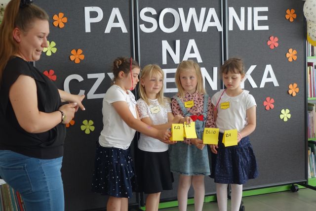 dzieci stoją z karteczkami żółtymi w rękach