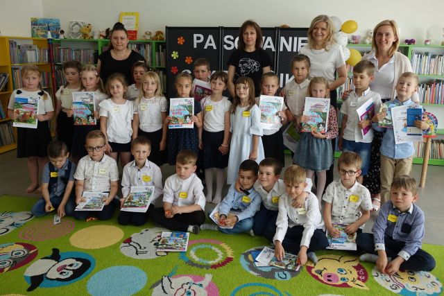 dzieci pozują do zdjęcia z bibliotekarkami i przedszkolankami