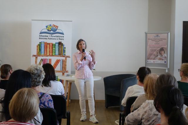 kobieta stoi i przemawia do publiczności