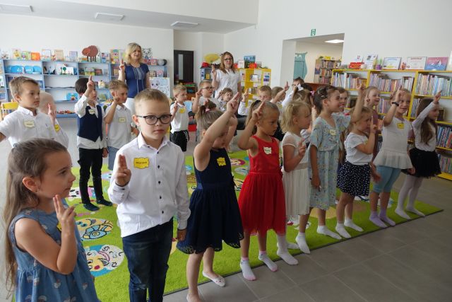 dzieci stoją trzymając do góry dwa palce prawej ręki i składają przysięgę