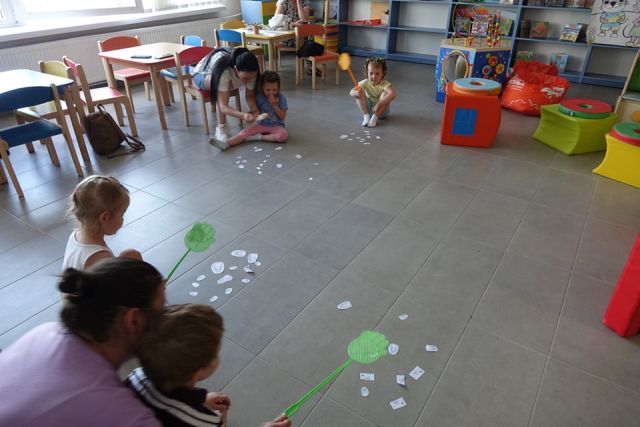 dzieci i rodzice przy pomocy łąpek na muchy łapią karteczki