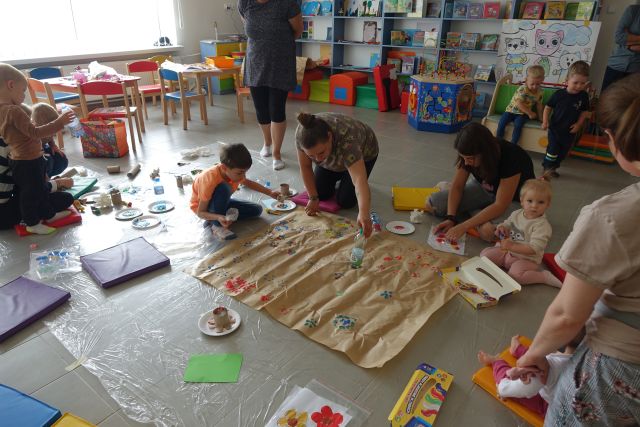 dzieci i rodzice na podłodze malują farbkami