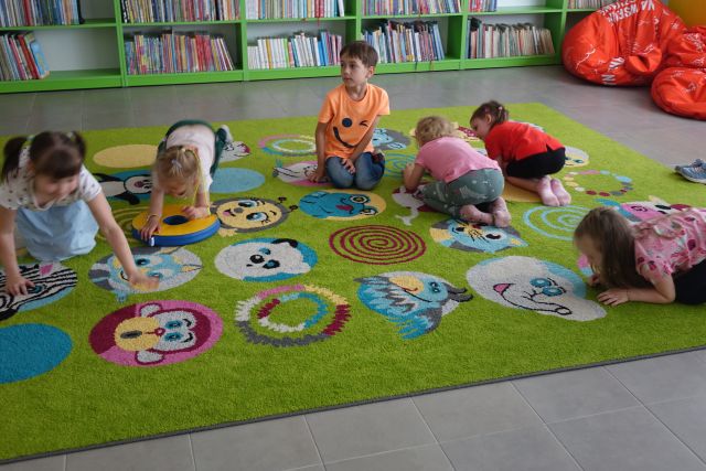 dzieci wykonują kocie ruchy na kolorowym dywanie