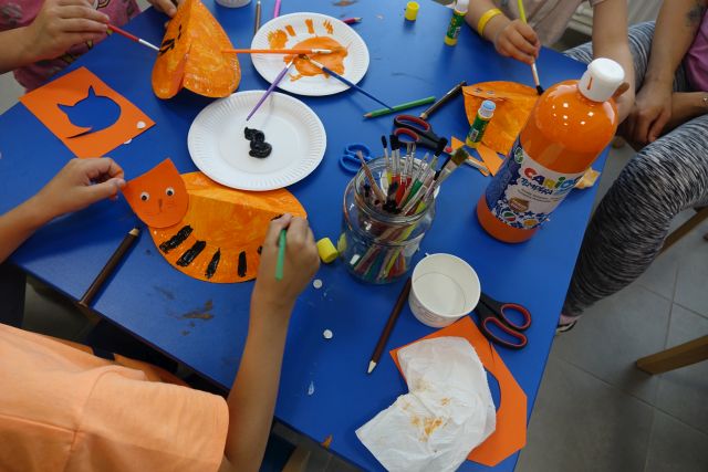 dzieci malują na papierowych talerzykach koty