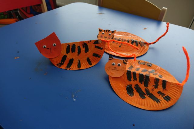 trzy pomarańczowe koty z pregami namalowane na papierowych talerzykach