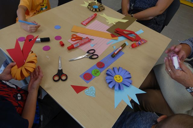 na stoliku wykonaneprzez dizeci medale z kolorowego papieru, nożyczki, kleje