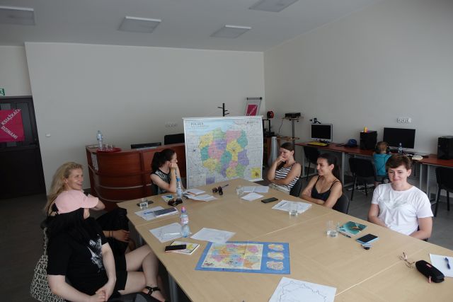 6 kobiet siedzi przy stołach na któych ma rozłożone zeszyty do nauki