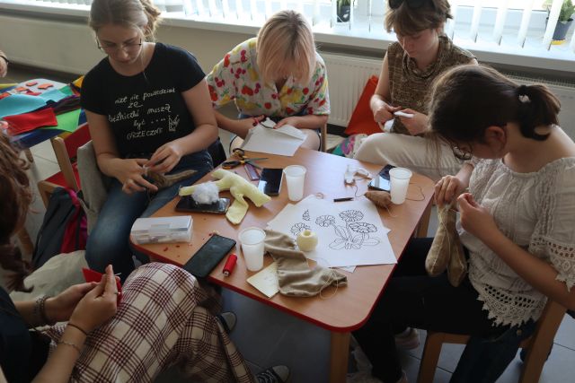 uczestnicy projektu szyją i wykrawają z materiałów