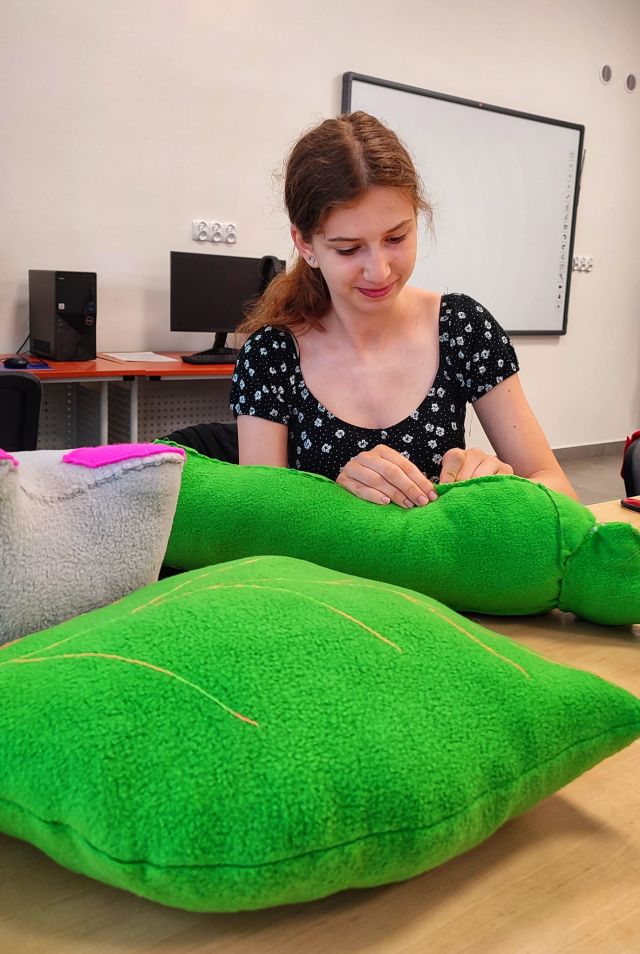 dziewczyna szyje zieloną gąsienicę