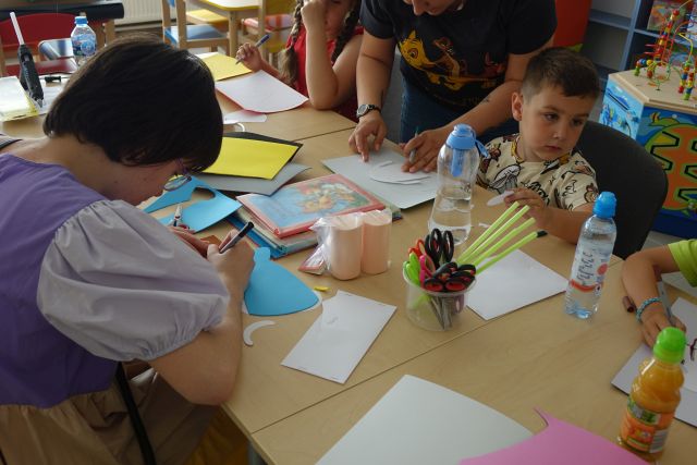 dzieci wycinają z papieru, kleją