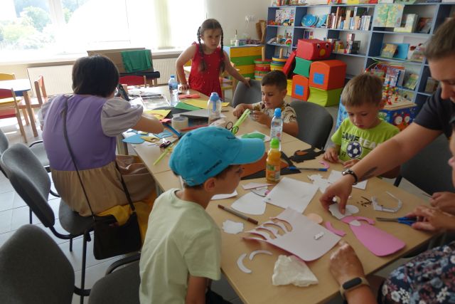 dzieci wycinają z papieru, kleją i tworzą kukiełki