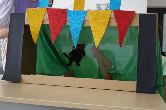 dwie kukiełki w teatrzyku stworzonym z kartonu