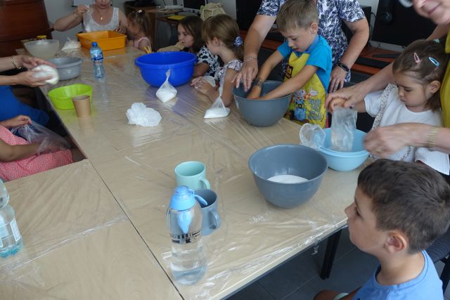 dzieci z pomocą rodziców robią w miskach masę solną