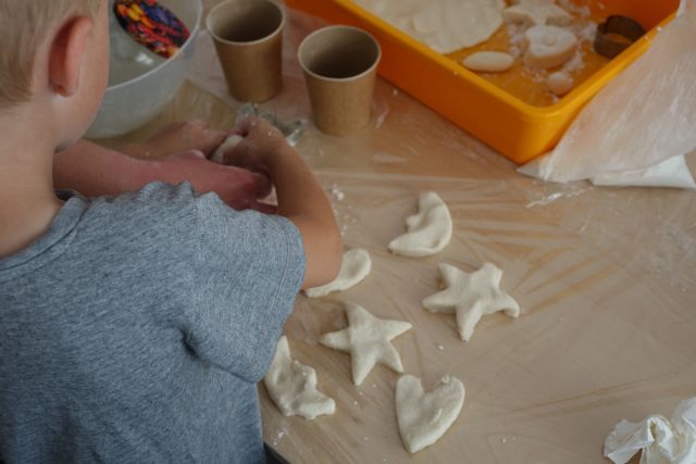 dzieci z masy solnej wykrawają figurki foremkami do ciasta