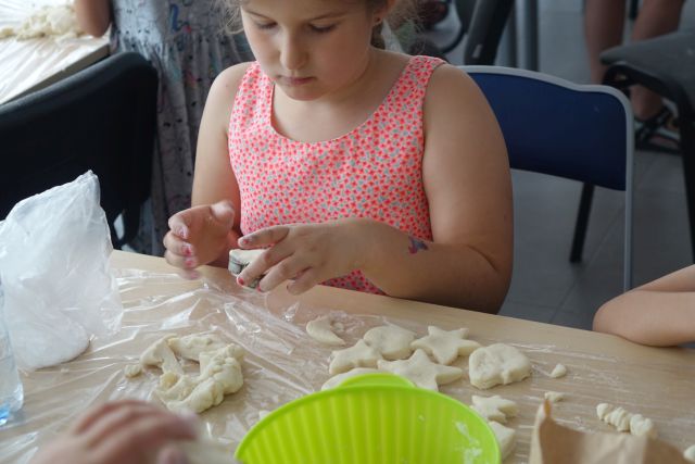 dziewczynka wykrawa figurki z masy solnej