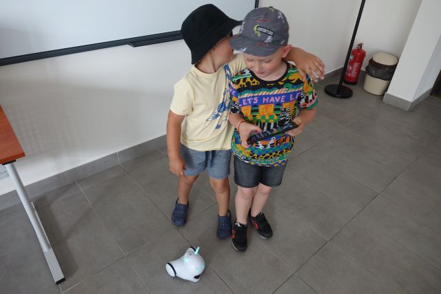 dwóch chłopców bawi się robotem